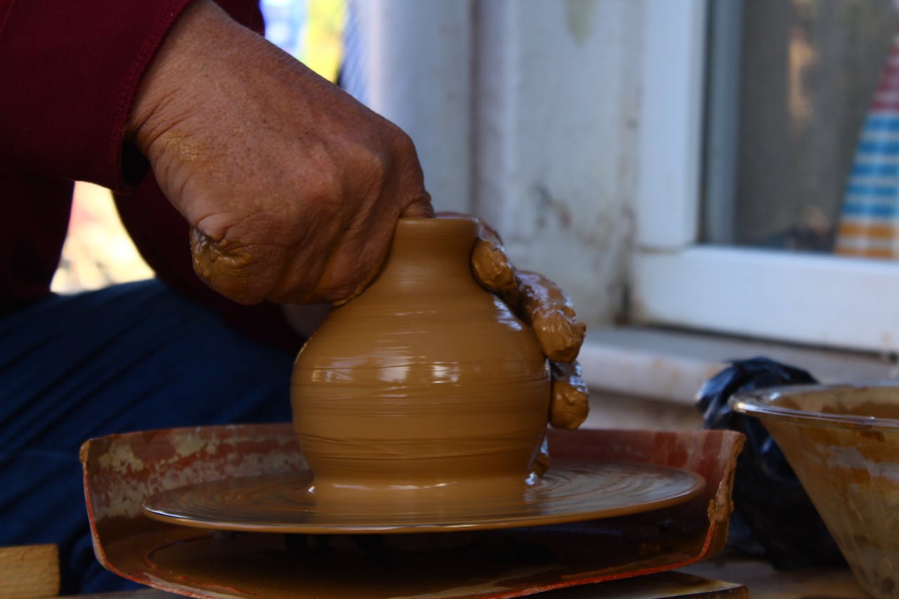contact-header artisan-crafting-clay-pot-on-pottery-wheel-34461173